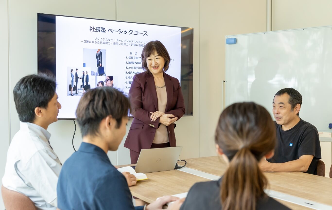 笑顔でプログラムをしている講師と楽しそうに受講している生徒